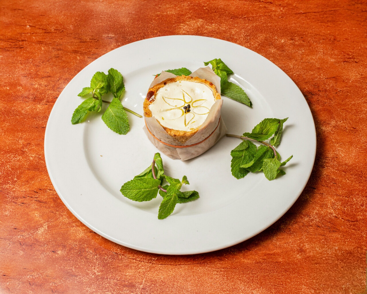 Elegantly plated dessert with decorative icing and fresh mint garnish