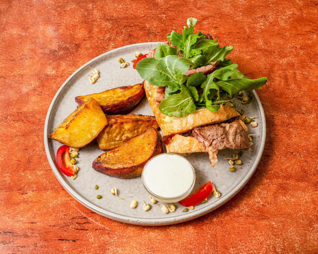 Gourmet steak with fresh arugula salad and roasted potato wedges
